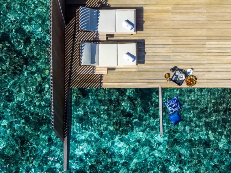 Aerial view of an overwater villa deck and turquoise lagoon at St. Regis Vommuli